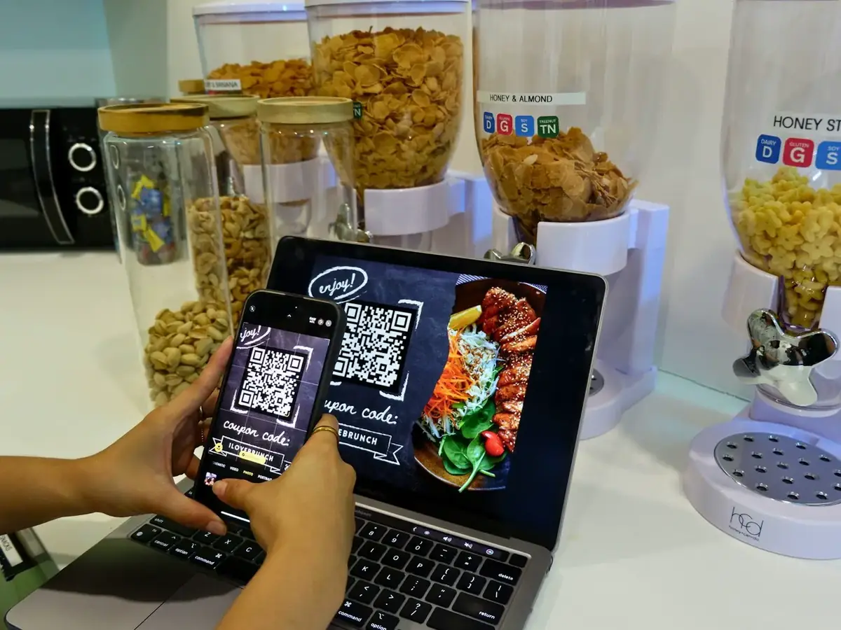 A person scanning a QR code menu with a phone at a table