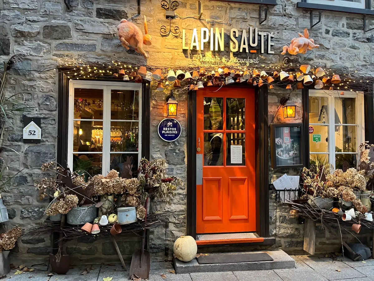 La façade en pierre d’un restaurant à la porte rouge, à Québec